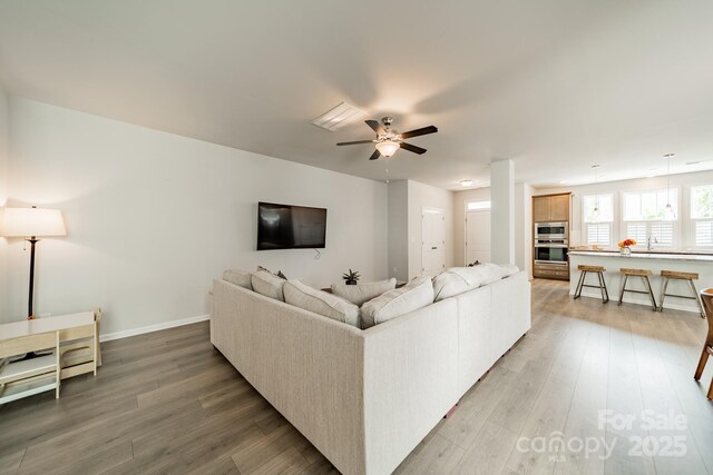 804 Lyndon Station Dr, Pineville, NC 28134 - living area with a ceiling fan, baseboards, and light wood-style flooring