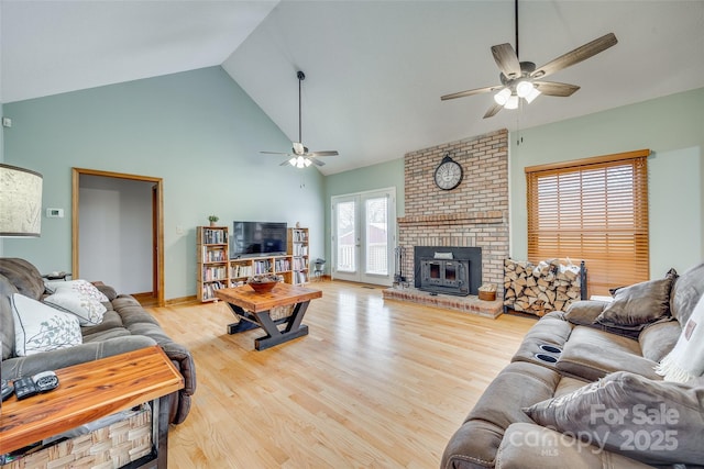 living room with high vaulted ceiling, wood finished floors, ceiling fan, and a brick fireplace