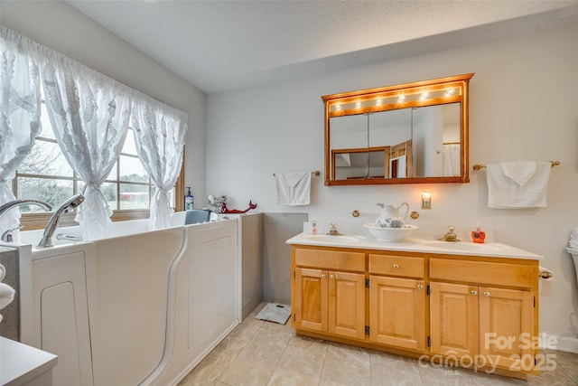 full bath featuring double vanity, a bathtub, tile patterned flooring, and a sink