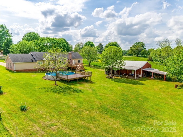 view of yard with an outdoor structure, a deck, and an outbuilding