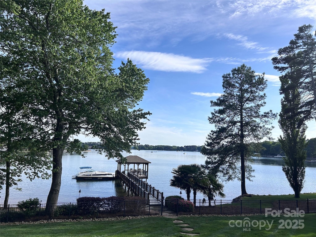 view of dock featuring a water view and fence