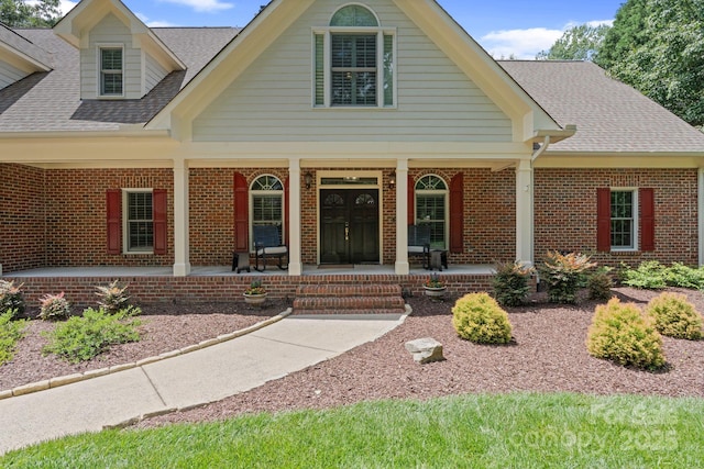 17112 Green Dolphin Ln, Cornelius, NC 28031 - view of front of house with covered porch, a shingled roof, and brick siding