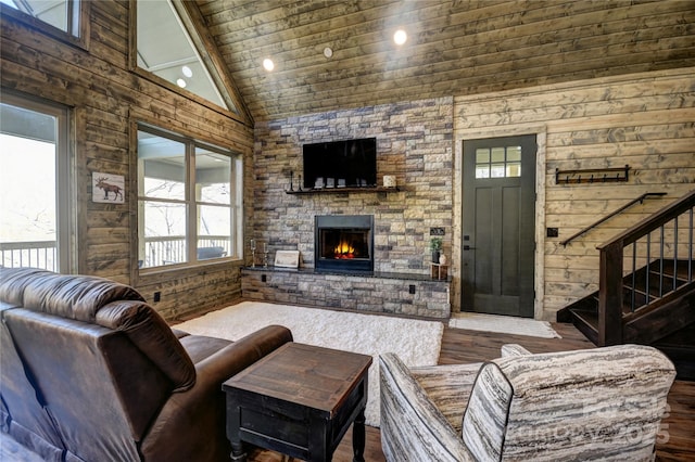 601 Tater Patch Rd, Maggie Valley, NC 28751 - living room featuring plenty of natural light, a stone fireplace, high vaulted ceiling, wooden walls, and wood finished floors