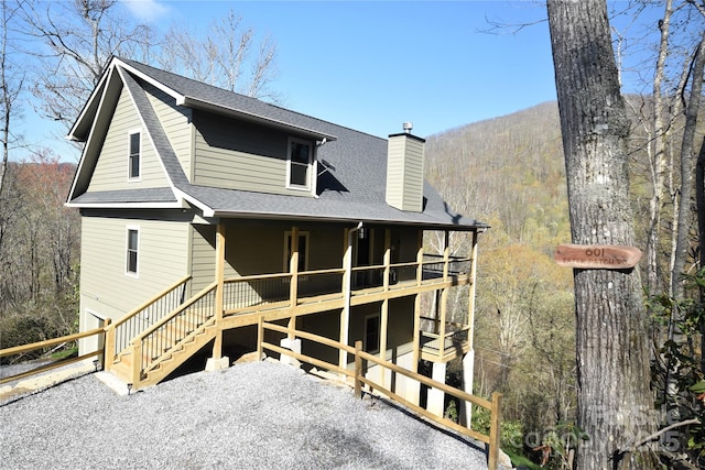 601 Tater Patch Rd, Maggie Valley, NC 28751 - rear view of property with a chimney, a shingled roof, a porch, and a wooded view