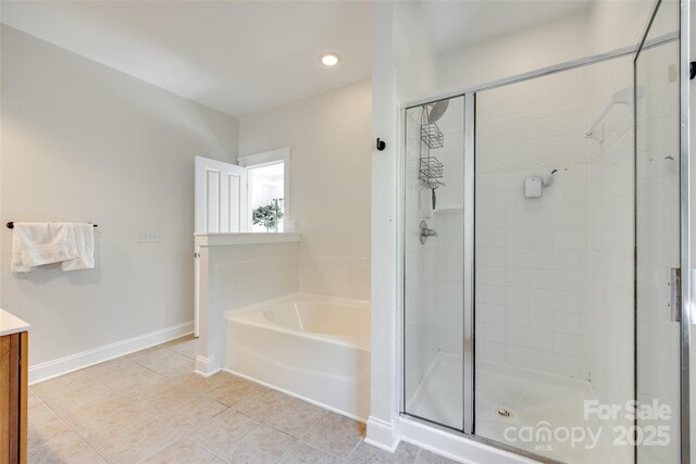 full bath with tile patterned flooring, vanity, a garden tub, baseboards, and a shower stall