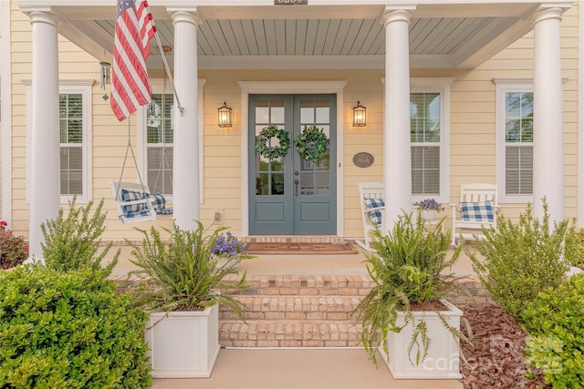 property entrance featuring a porch and french doors