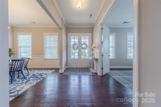 entryway with crown molding, hardwood / wood-style floors, baseboards, and visible vents