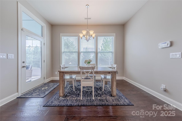 dining area featuring an inviting chandelier, dark wood-type flooring, visible vents, and baseboards