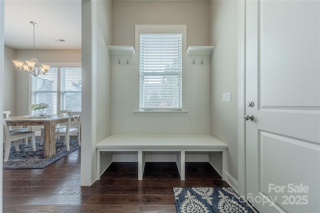 mudroom featuring dark wood-type flooring and a chandelier