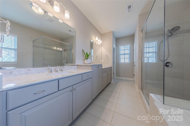 bathroom with vanity, a stall shower, visible vents, baseboards, and tile patterned flooring