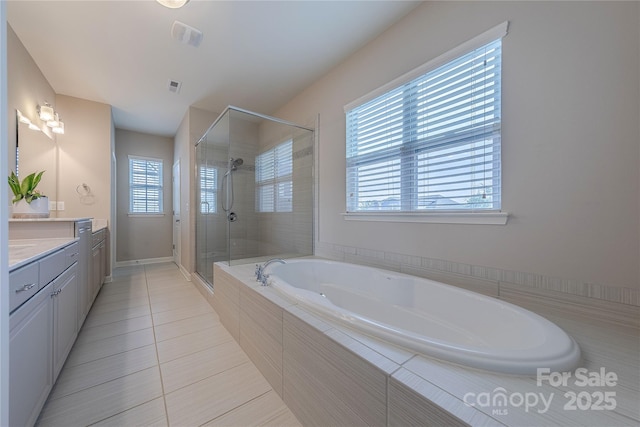 full bathroom with a stall shower, a healthy amount of sunlight, a bath, and vanity