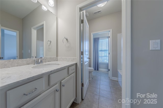 bathroom featuring toilet, vanity, visible vents, and tile patterned floors