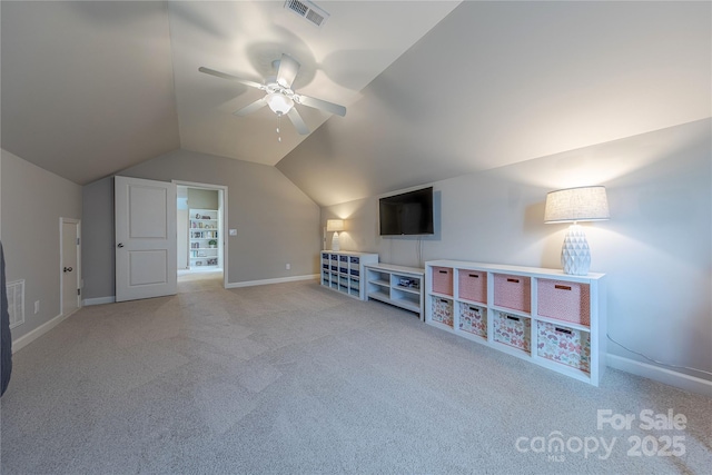 interior space featuring vaulted ceiling, light carpet, baseboards, visible vents, and a ceiling fan