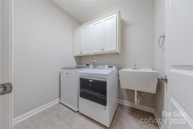laundry room featuring baseboards, a sink, cabinet space, and washing machine and dryer