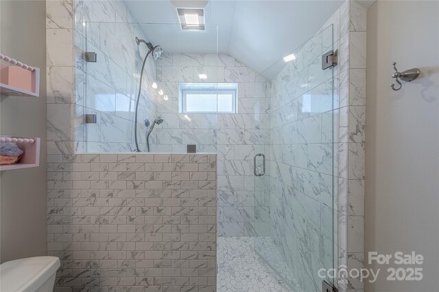 full bath with toilet, a shower stall, and vaulted ceiling