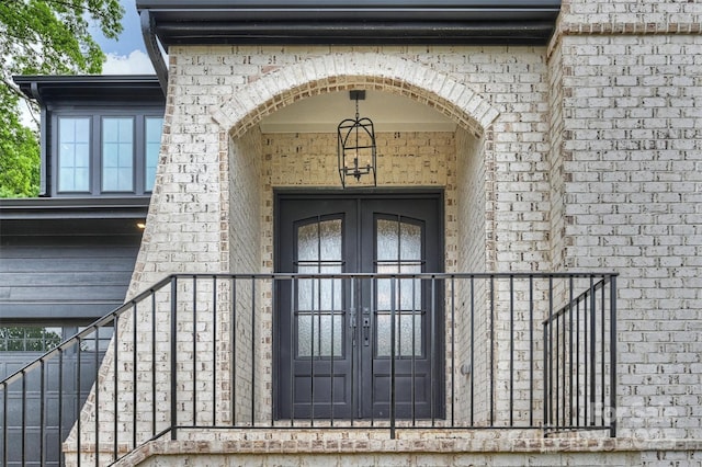 doorway to property featuring french doors and brick siding