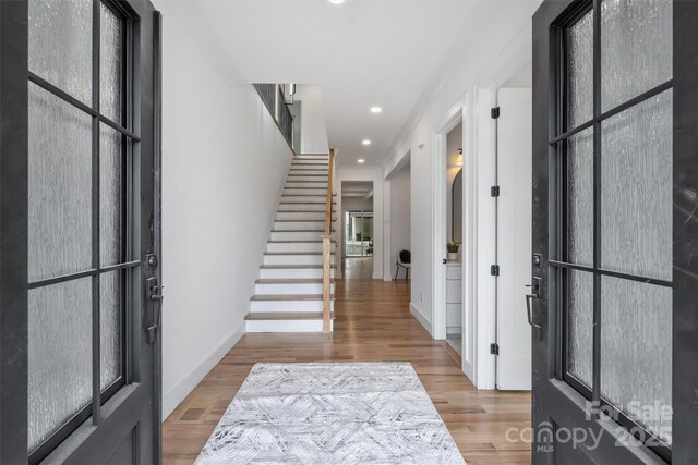 foyer with baseboards, stairway, wood finished floors, and recessed lighting