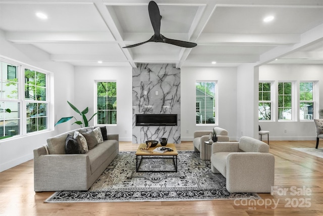 living room with coffered ceiling, baseboards, wood finished floors, and plenty of natural light