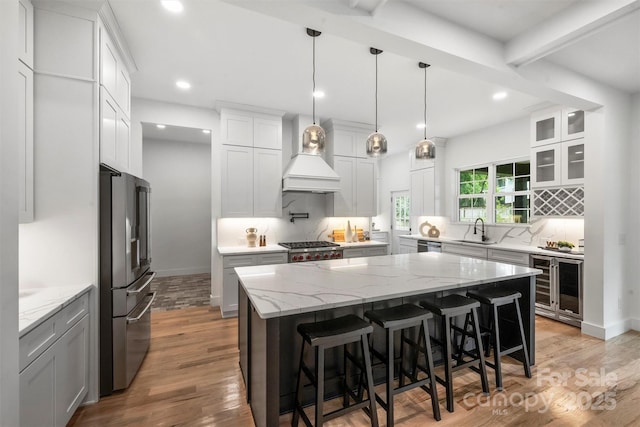 kitchen with tasteful backsplash, a sink, appliances with stainless steel finishes, beverage cooler, and recessed lighting