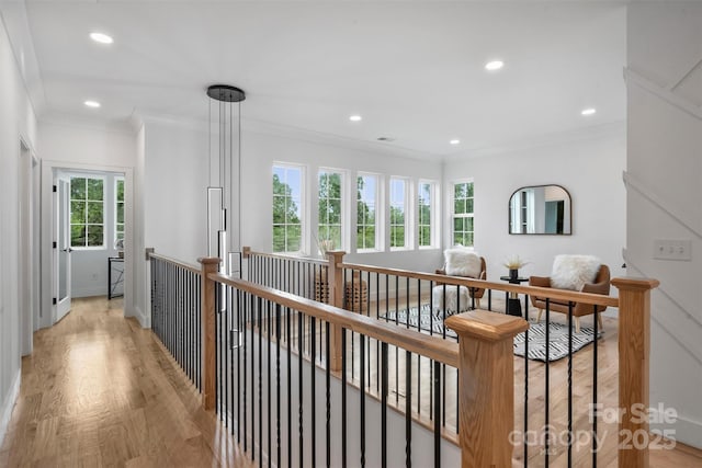 hall with crown molding, recessed lighting, an upstairs landing, and light wood-style floors