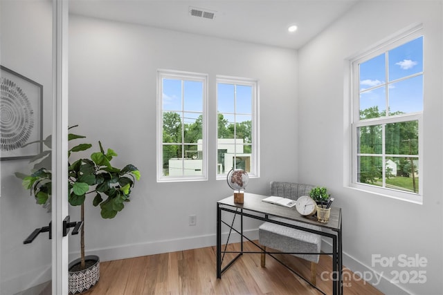 office featuring wood finished floors, visible vents, and baseboards