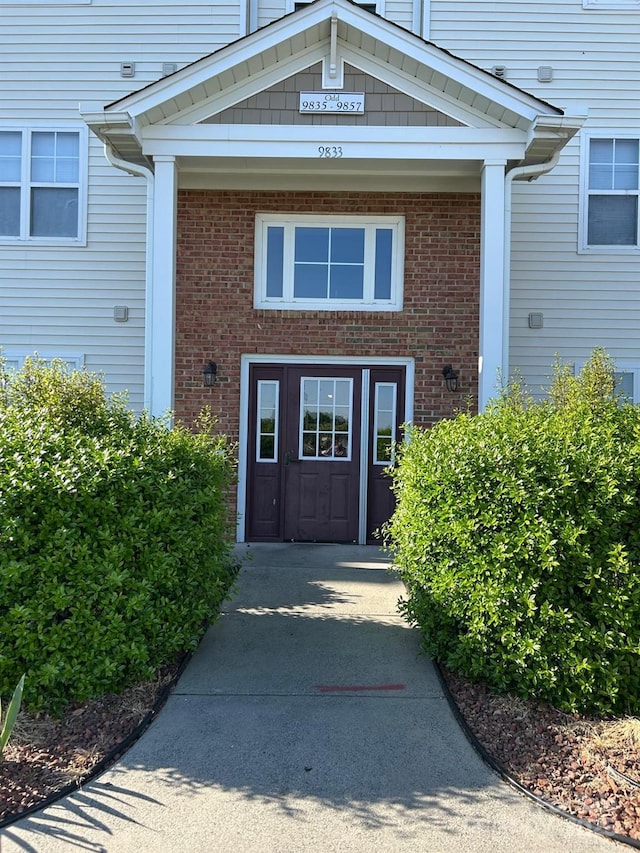 view of exterior entry with brick siding