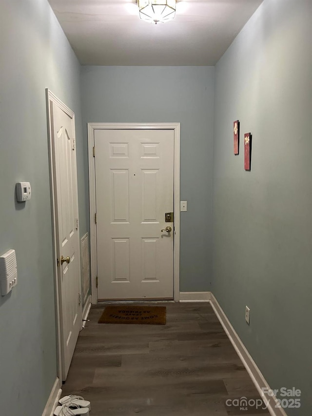 doorway featuring dark wood-style floors and baseboards