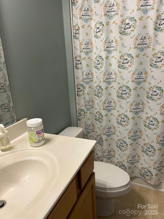 bathroom with tile patterned floors, a shower with shower curtain, toilet, and vanity