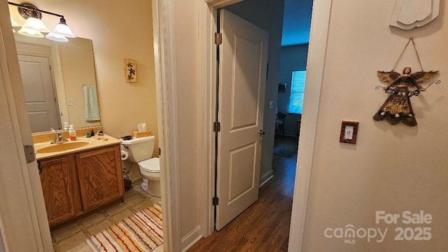 bathroom featuring vanity, wood finished floors, and toilet