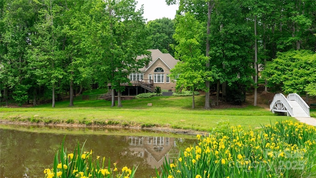 view of yard featuring stairway and a deck with water view