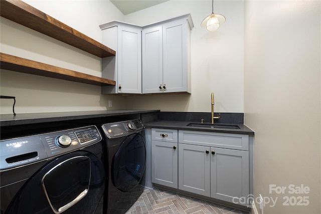 clothes washing area featuring washing machine and dryer, cabinet space, brick floor, and a sink