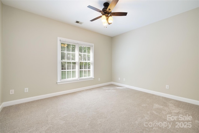 spare room featuring carpet flooring, visible vents, ceiling fan, and baseboards