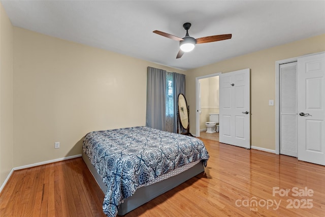 bedroom featuring light wood finished floors, connected bathroom, baseboards, and ceiling fan