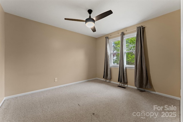 carpeted empty room featuring visible vents, baseboards, and a ceiling fan