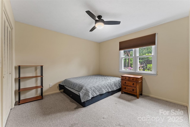 carpeted bedroom featuring ceiling fan, a closet, and baseboards