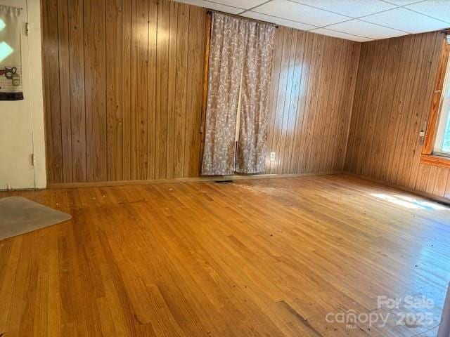 unfurnished room with wood walls and wood finished floors
