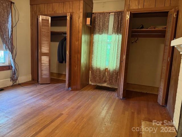 unfurnished bedroom featuring wood finished floors and baseboards