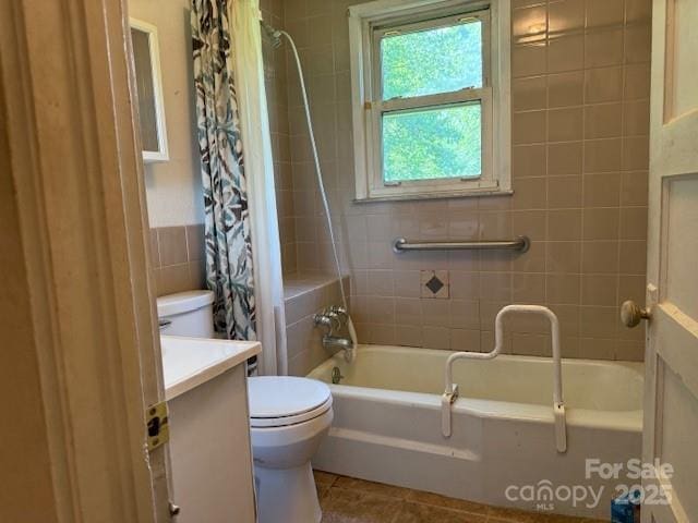 full bathroom featuring shower / bath combo, toilet, tile walls, tile patterned floors, and vanity