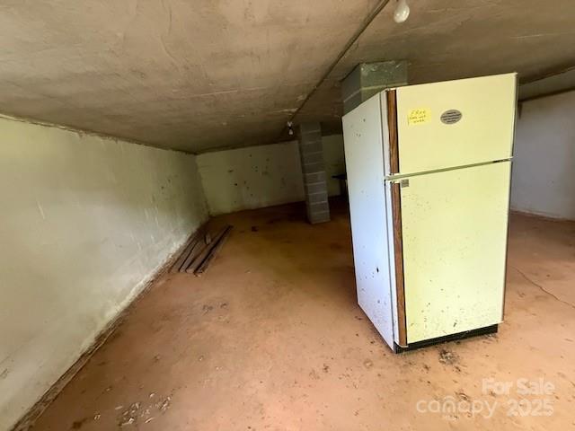 below grade area with freestanding refrigerator
