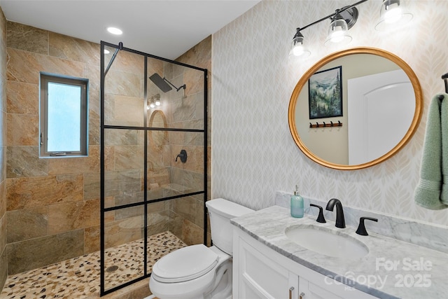 full bath featuring toilet, wallpapered walls, a tile shower, and vanity