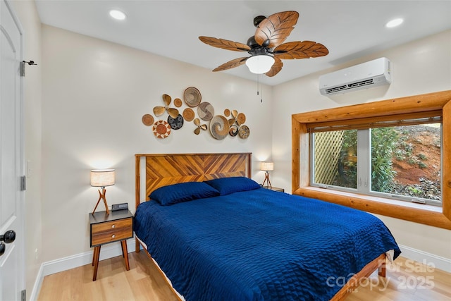 bedroom with baseboards, recessed lighting, a wall mounted air conditioner, and wood finished floors