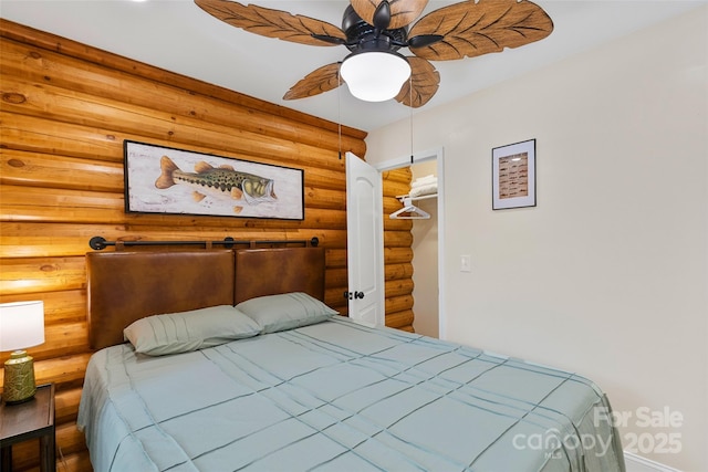 153 Chetan Way, Lake Lure, NC 28746 - bedroom featuring a walk in closet, rustic walls, ceiling fan, and baseboards