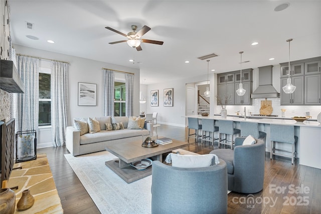 living room with visible vents, recessed lighting, dark wood-style flooring, and ceiling fan
