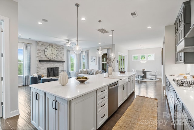 kitchen featuring visible vents, a ceiling fan, a spacious island, a sink, and stainless steel appliances