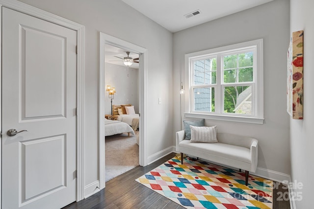 living area with baseboards, a ceiling fan, dark wood-style floors, and visible vents