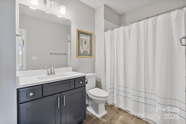 full bathroom featuring vanity, curtained shower, wood finish floors, and toilet