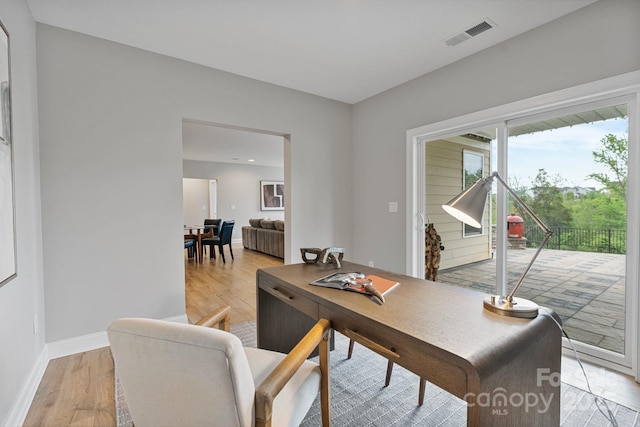 office with baseboards, light wood-type flooring, and visible vents