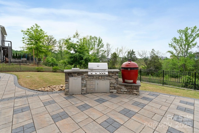 view of patio featuring area for grilling, exterior kitchen, and a fenced backyard
