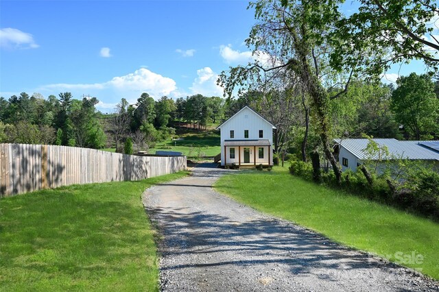 exterior space featuring fence, driveway, and a front yard