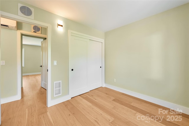 338 Emma Rd, Asheville, NC 28806 - unfurnished bedroom with light wood finished floors, baseboards, and a closet